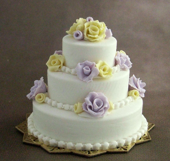 Three-tiered wedding cake with lilac and yellow roses